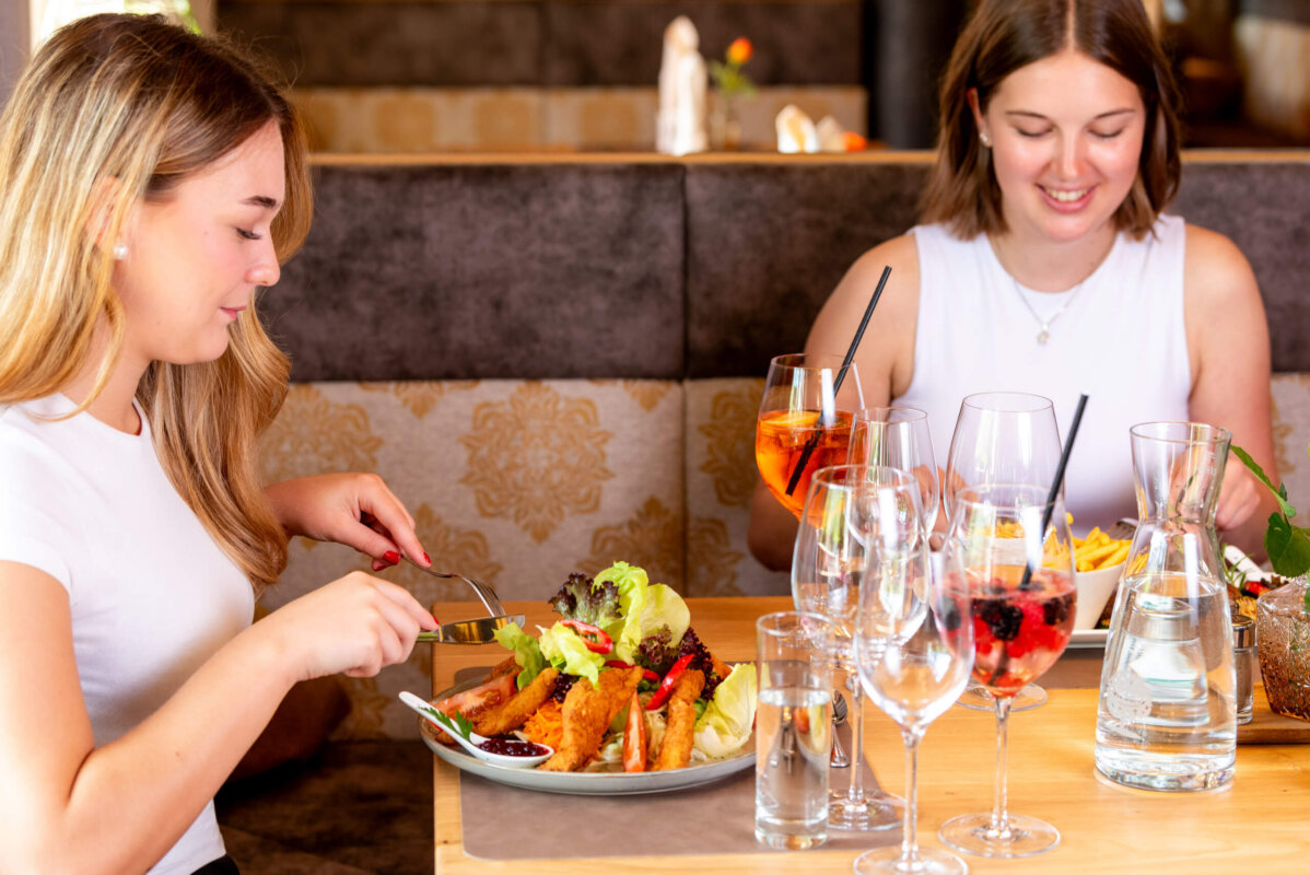 2 junge Damen am Essen im Restaurant